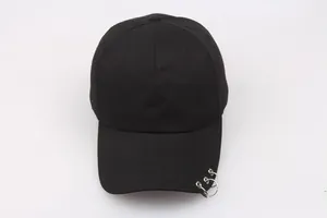 Detail shot of black cotton baseball cap featuring three silver metal rings on the brim
