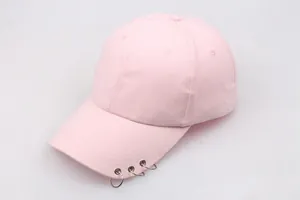 Detailed shot of pink cotton baseball cap featuring three silver metal rings on the brim