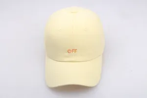 Detail of light yellow cotton baseball cap featuring orange OFF text and power icon