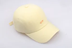 Detail of light yellow cotton baseball cap with orange OFF embroidery and adjustable strap