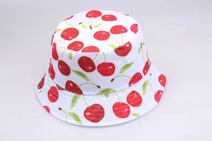 Detailed view of white bucket hat featuring red cherry prints and reinforced stitching
