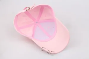Detail of pink canvas baseball cap interior with adjustable buckle and three silver rings