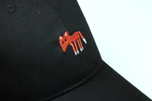 Detail der hochwertigen orangefarbenen Fuchstickerei auf schwarzer Baumwollkappe