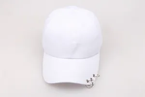 Detail of white cotton baseball cap showing three silver metal rings on the brim