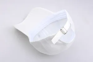 Dettaglio dell'interno del cappellino bianco con fibbia in metallo e cotone