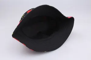 Detailed close-up of printed cotton bucket hat showing red cherry pattern and stitched brim