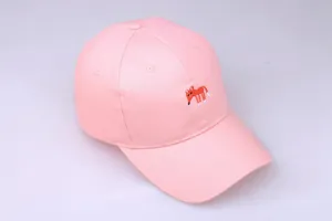 Detailansicht der orangefarbenen Fuchstickerei auf einer hellrosa Baumwoll-Baseballkappe