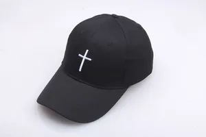 Classic black cotton baseball cap with white cross embroidery in a 45-degree angle view