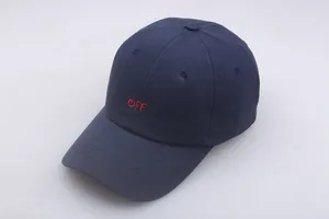 Detail of navy blue cotton baseball cap with red embroidered power switch and OFF logo