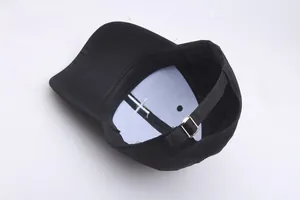 Internal view of black cotton baseball cap showing white front lining and metal buckle