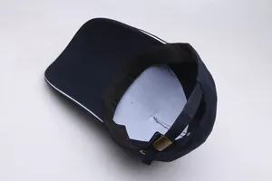 Detail view of adjustable metal buckle and inner sweatband of navy blue baseball cap