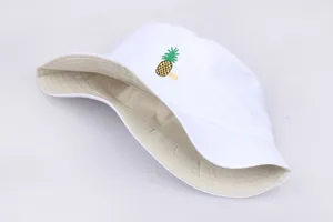 Detalle del sombrero de pescador reversible blanco con bordado de piña y texto Pin bordado