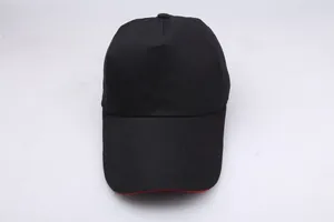 Detail of black baseball cap showing red contrast edge on the brim and cotton fabric