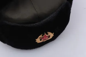 Detail of army green ushanka earflap hat with black faux fur and red star Soviet badge