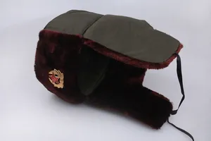 Detail of winter trapper hat with dark green canvas, brown faux fur, and red star badge