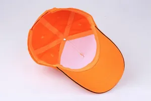 Detail of the bright orange 5-panel cotton baseball cap showing reinforced inner seams