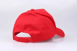 Detail view of red cotton baseball cap featuring adjustable velcro strap and sandwich brim