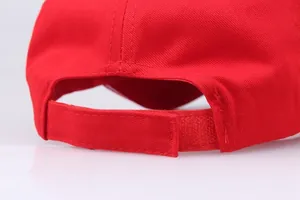 Detail view of red cotton baseball cap with adjustable velcro closure and textured fabric