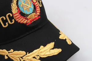 Detailed close-up of golden CCCP emblem and oak leaf embroidery on a black baseball cap