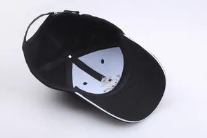 Detail view of adjustable black cotton baseball cap showing white lining and metal buckle