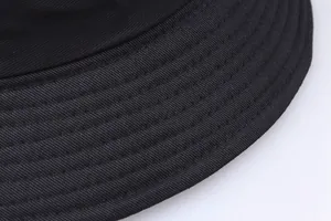 Macro view of multi-row reinforced stitching on black cotton bucket hat brim