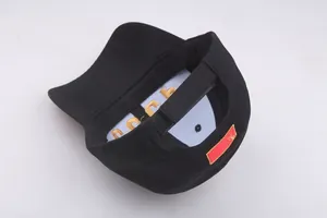 Detail of black cotton CCCP cap showing adjustable strap and golden inner embroidery