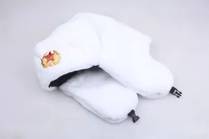 Macro shot of white plush Soviet-style Ushanka hat featuring a red star badge