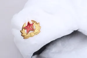Detailed close-up of a white plush Ushanka hat featuring a Soviet red star metal badge