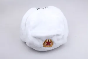 Detailed view of white faux fur ushanka hat with gold Soviet hammer and sickle emblem