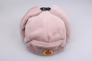 Detail of pink faux fur ushanka with Soviet emblem and black buckle strap closure