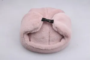 Detail view of pink plush trapper hat showing soft faux fur texture and plastic buckle