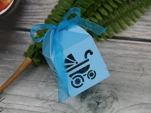 Macro detail of laser-cut baby carriage hollow gift box with blue ribbon bow decor