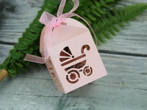 Detail of pink laser-cut stroller gift box with ribbon for baby shower candy packaging