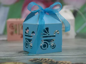 Macro detail of laser-cut baby carriage candy box in blue cardstock with ribbon