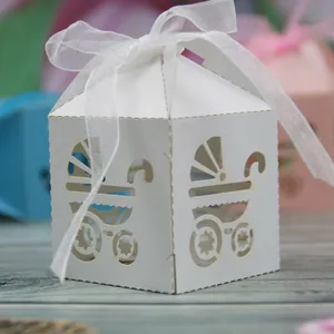 Detail view of white laser-cut baby stroller candy box with ribbon for baby showers