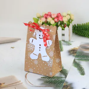 Sacchetto regalo di Natale in carta kraft con fiocchi di neve e ciondolo omino di pan di zenzero