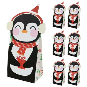 Christmas paper gift bags featuring a cute cartoon penguin with festive snowflake patterns