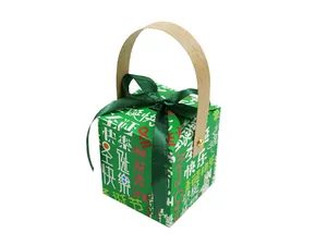 Detail of green Christmas gift box with Merry Christmas prints and dark green satin bow