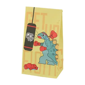 Detailed side view of yellow paper bag with cartoon dinosaur boxing graphic print
