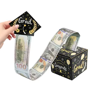 Detail view of pulling play money from a black and gold graduation surprise money box
