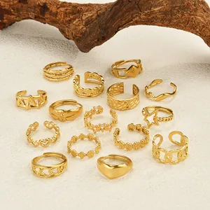 Set mit 14 goldenen geometrischen Ringen mit Herz- und Sternmotiven auf strukturiertem Holz