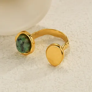 Detail of gold-plated open ring featuring a turquoise stone and hammered texture