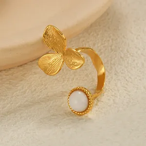 Detailed close-up of a gold-plated flower ring with white stone and clover petal texture