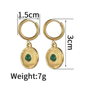 Detailed view of 14K gold-plated earrings with sunburst texture and green stone inlay