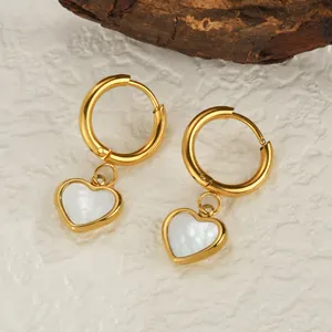 Elegant gold heart earrings with shell inlay and 18K plating on a minimalist white backdrop