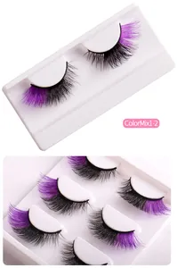 Détails de faux cils volumineux noirs et violets mélangés sur un plateau blanc