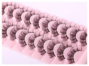 Dettaglio macro di 14 paia di ciglia finte nere spesse e ricce su vassoio rosa