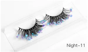 Close-up of artistic handmade eyelashes with colorful glitter and purple sequins