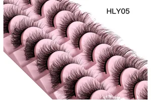 Macro detail of 10 pairs of multi-layered cat eye lashes on a pink tray