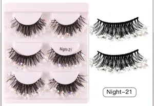 Detail of Night-21 dense stage eyelashes with iridescent sequins on a white tray